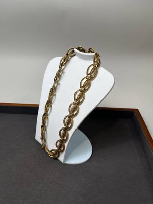 un gros plan d'un collier posé sur un présentoir posé sur une table