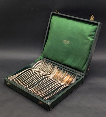 a green case with silverware in it on a black background