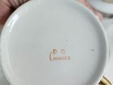 a person holding a cup and saucer on a table