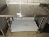 une table en inox dans une cuisine au sol carrelé