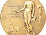 an image of a gold medal with a woman holding a hammer