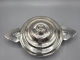 a silver plate with a circular design on the top