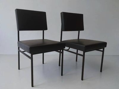 pair of black leather dining chairs with black metal legs