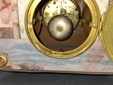 a gold clock sitting on top of a marble table