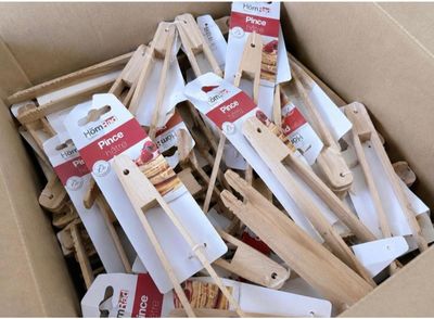 a cardboard box filled with wooden pegs and wooden spoons