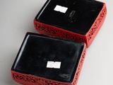 pair of black and red boxes on a white surface