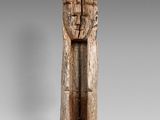 un gros plan d'une sculpture en bois représentant une personne sur un socle