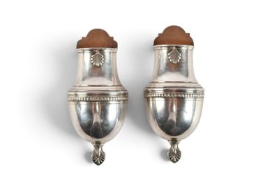deux vases en argent posés sur une surface blanche