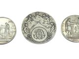 three different types of silver coins on a white surface
