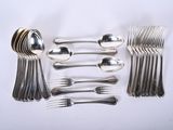 a lot of silver spoons and forks laid out on a table