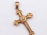 pendentif en forme de croix en or avec une perle au centre
