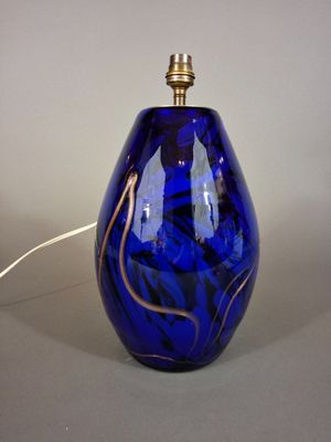 a blue glass lamp that is on a table
