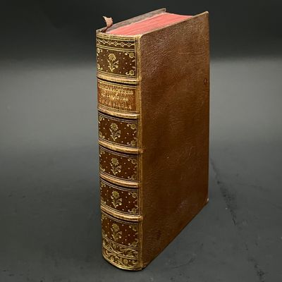 an old book sitting on top of a table next to a black background