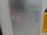 a close up of a white microwave with a yellow sign on it
