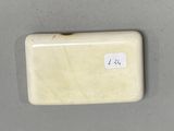 an ivory colored soap dish with a sticker on it