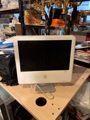 un ordinateur de bureau Apple posé sur un bureau en bois