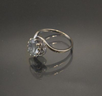 a white gold ring with a blue topaz stone in the center