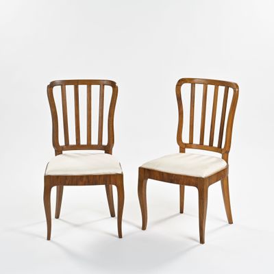 deux chaises en bois aux assises rembourrées blanches, sur fond blanc