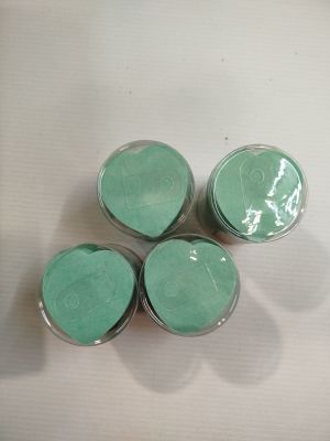 trois bocaux aux couvercles verts sont posés sur une surface blanche