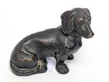 a small black dog figurine sitting on a white surface