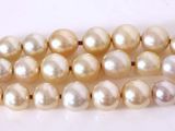 a close up of a row of pearls on a white surface