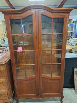a large wooden cabinet with glass doors in a room