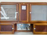 a wooden cabinet with glass doors and a mirror on it