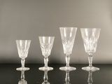 four empty wine glasses are lined up on a black table