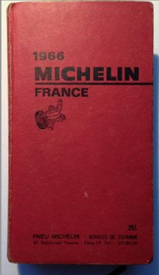 an old red book sitting on top of a white table