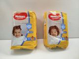 two packs of huggies diapers sitting on top of each other