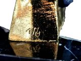 a gold piece sitting on top of a black marble table