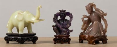 trois figurines représentant des éléphants et une femme, posées sur une table