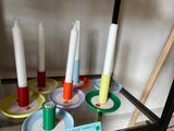 many different colored candles on display in a glass case