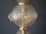 a glass vase with a gold handle on a table