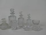 a lot of glass bottles and vases sitting on a table