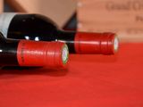two bottles of wine sitting on a red table