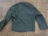 a green jacket on the floor on the wooden floor