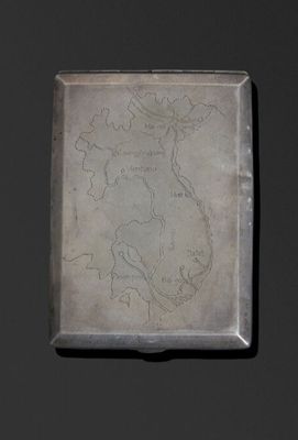 un vieux plateau en argent orné d'une carte, posé sur une table