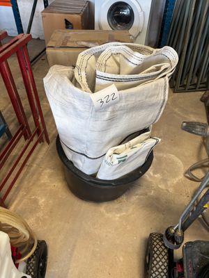une pile de sacs posée par terre à côté d'une machine à laver
