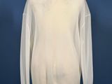 a white sweater on a mannequin stand against a blue wall