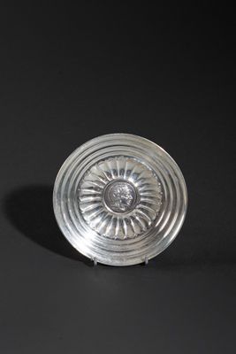 an antique silver plate on a black background with a black background