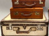 three suitcases stacked on top of each other on a table