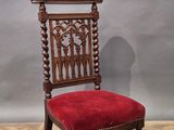 a red chair sitting on top of a wooden floor next to a gray wall