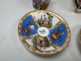 a plate with a picture on it next to a cup and saucer