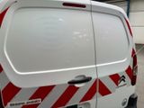 a white van with red and white stripes parked in a garage