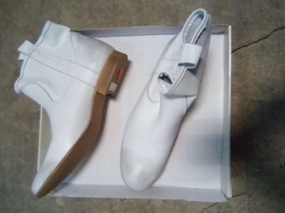 une paire de chaussures blanches dans une boîte posée par terre