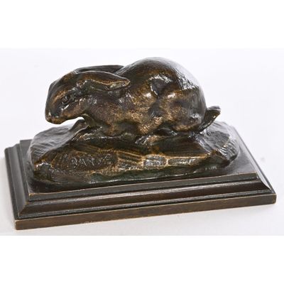 sculpture en bronze représentant un lapin posé sur un rocher, sur fond blanc