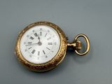 a gold pocket watch with roman numerals on it