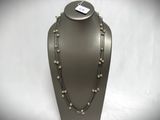 a necklace with pearls and chains on a mannequin