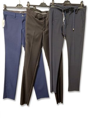 trois paires de pantalons pour homme suspendues à un portant